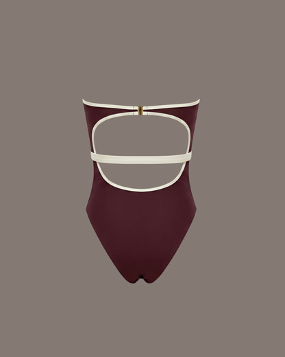 Amira One-Piece, maroon swimsuit with white accents shoot in a studio background.